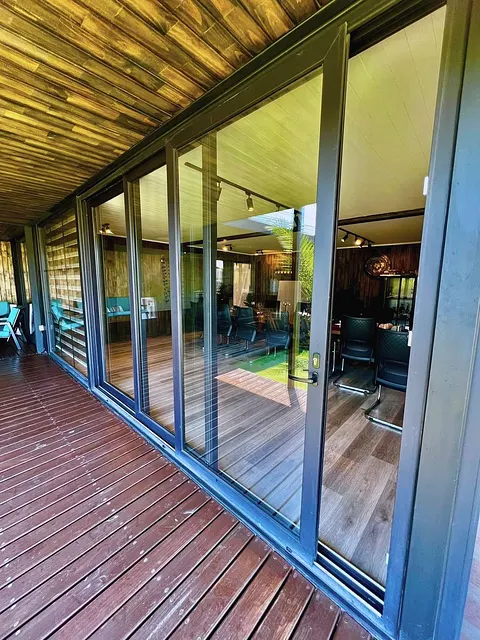 Corredera panorámica de cuatro hojas con perfil grafito sobre deck